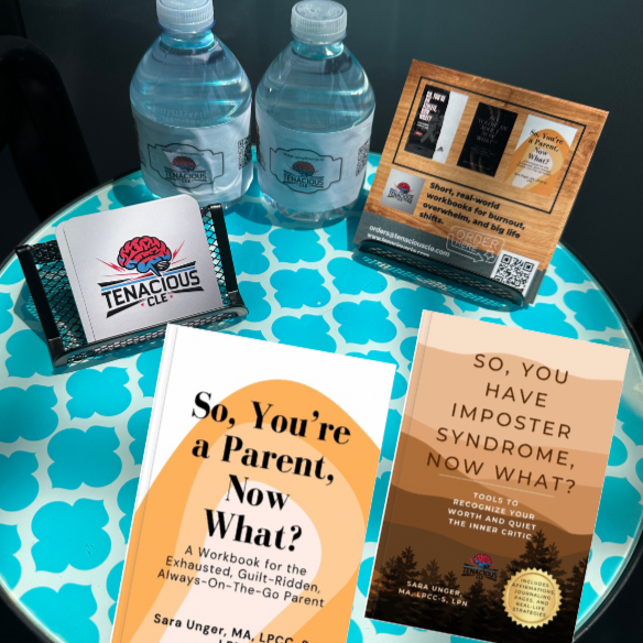 Table with books, water bottles, and a card on a blue patterned surface